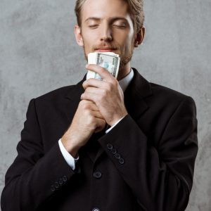 jovem-empresario-de-sucesso-em-terno-segurando-dinheiro_176420-1154